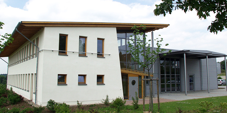 helles Gebäude mit silbernem Anbau